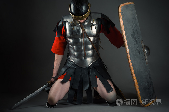 疲惫不堪的士兵跪着盾牌和剑在手中