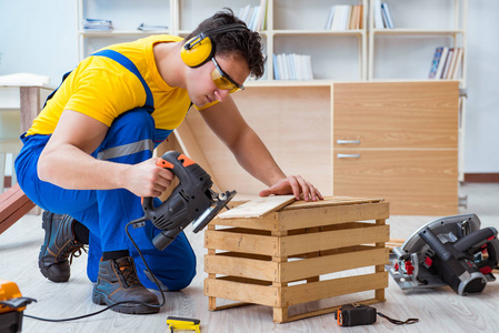 从实心松木中的预切木材站起男性在工作场所锯木头.