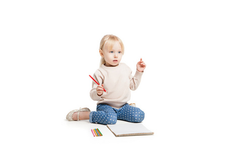 小可爱的女孩坐在地板上，用五颜六色的钢笔画画