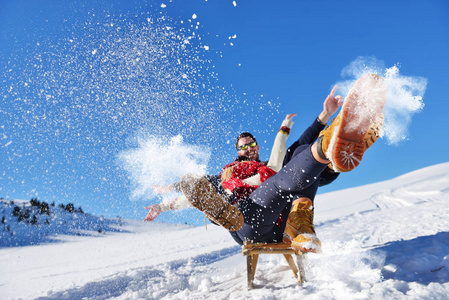 小两口滑雪橇和享受阳光明媚的冬日