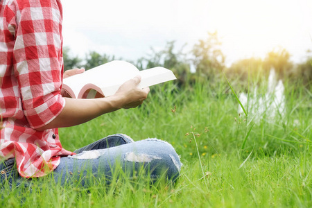 女人放松户外看起来非常快乐和读一本书。早上拿着一本书。放松的概念。复古的滤镜效果 柔焦 选择性焦点