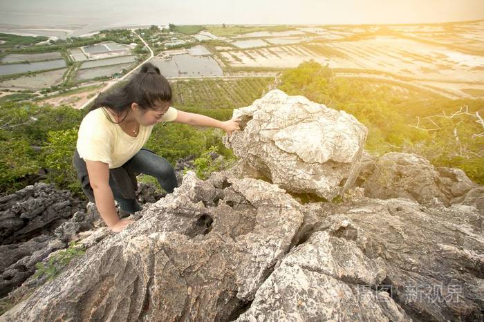 漂亮亚洲女人爬到山的顶峰