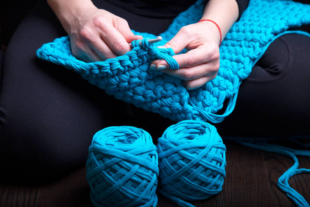 特写的女人手蓝色针织用纱。自由职业者的创造性的工作和生活概念