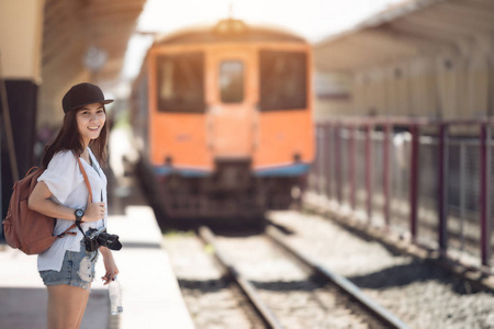 旅行者女人走路和等待火车铁路平台上。文塔