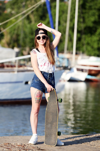 滑板，在户外的漂亮纹身的女孩