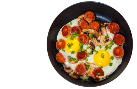 煎的鸡蛋在平锅里煎香肠和蘑菇。顶视图。孤立对白色