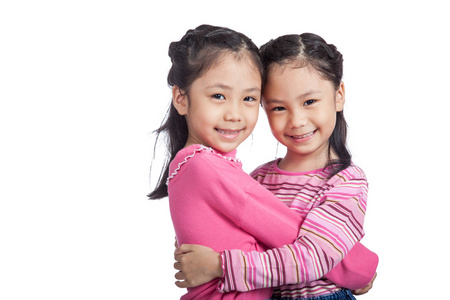 快乐的亚洲孪生姐妹互相拥抱图片