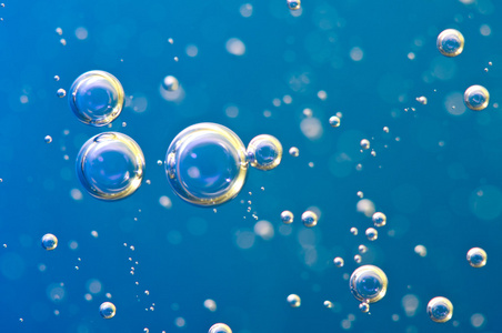 宏氧气气泡水在蓝色背景上照片