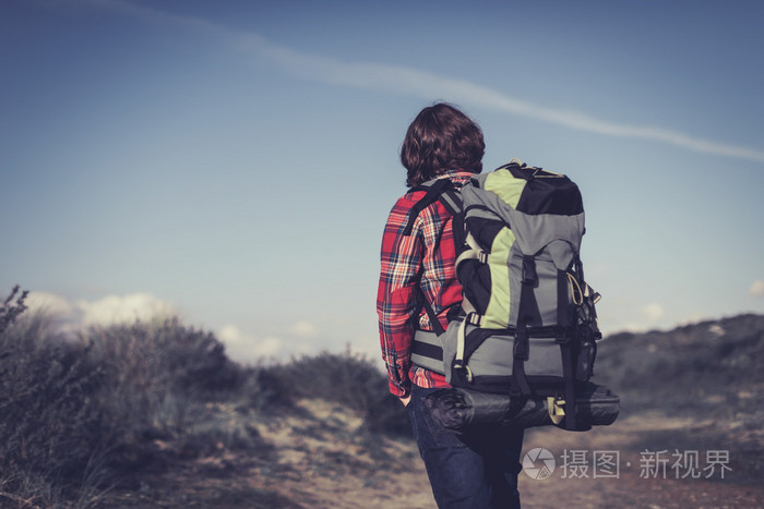 步行穿过丘陵灌丛的背包客