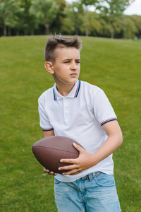 男孩抱着橄榄球球