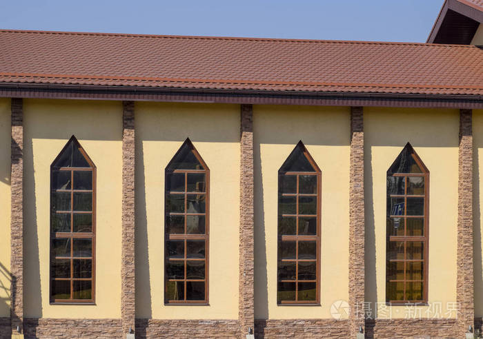 建筑与黄色墙壁和红棕色屋顶。现代材料的成品和屋面