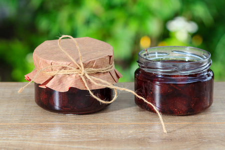 传统自制草莓酱放在木制的桌子上的罐子里
