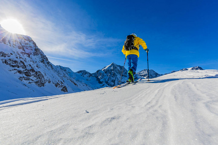 走上沿与白雪皑皑的山脊的登山野外滑雪