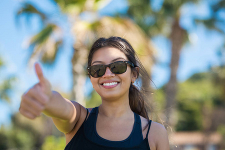 年轻漂亮的女人,显示大拇指微笑照片
