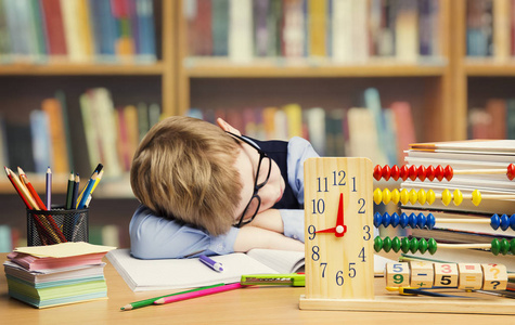 学生儿童在学校，累了的孩子睡在桌子上睡觉