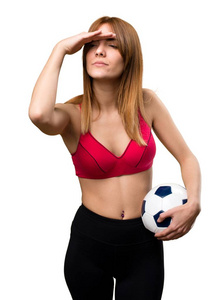 年轻的运动位妇女抱着一个足球