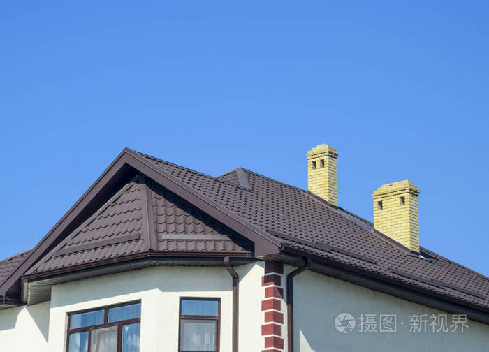 屋面的金属型材波浪形状上有塑料窗户的房子