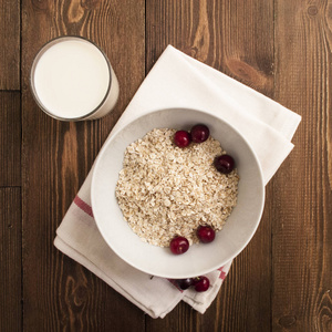 碗, 麦麸, 牛奶和新鲜的樱桃,木制背景,饼干的信件,形式上顶视图照片