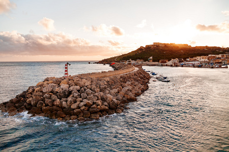 海湾海滨入口，日落时在海滨有灯塔。