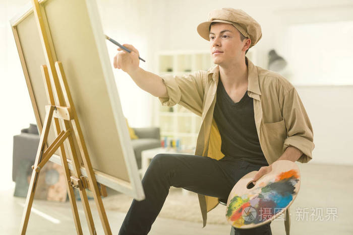 十几岁的画家用画笔在画布上绘画
