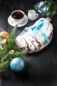 德式圣诞蛋糕与白杯热咖啡的银托盘上
