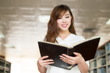 亚洲女学生举行书在图书馆