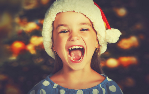 快乐的孩子在圣诞帽子的女孩