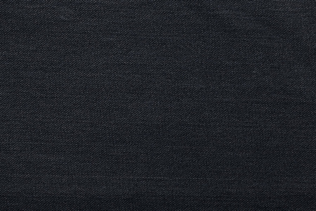 黑色背景上,粗斜纹棉布牛仔裤背景.牛仔裤贴图织物照片
