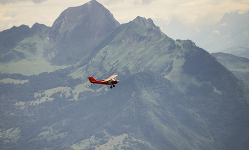 一架红色的小飞机飞过法国阿尔卑斯山
