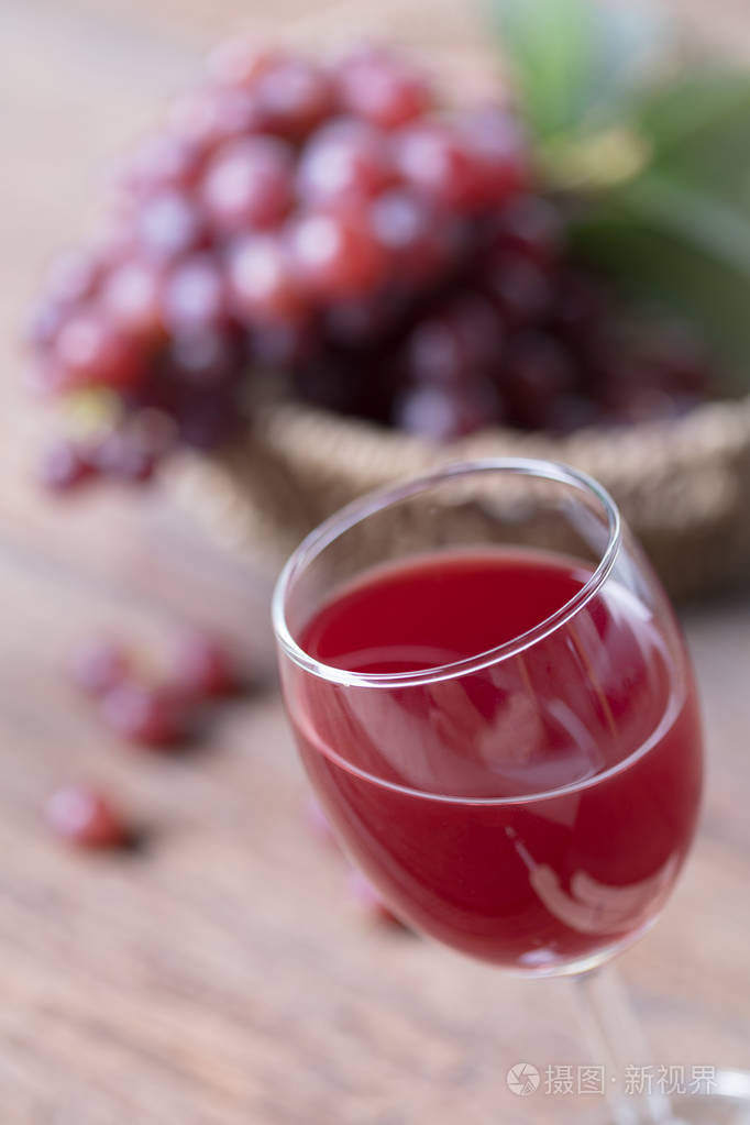 杯酒或葡萄汁和木制的桌子上的水果