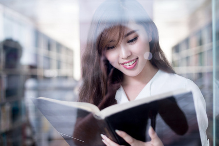 亚洲女学生举行书在图书馆