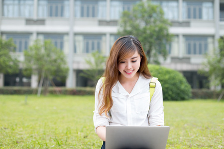 亚洲女学生在校园中使用笔记本电脑