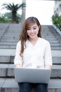 亚洲女学生在校园中使用笔记本电脑