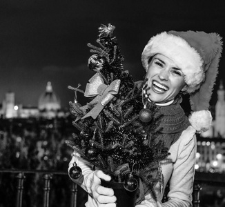旅行充满灵感在圣诞节的时候在佛罗伦萨。佛罗伦萨，意大利与圣诞树圣诞帽子微笑的年轻女子的画像