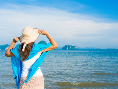 在夏天度假穿夏天帽子和海滩的女人穿衣服看这美丽的景色，在海洋