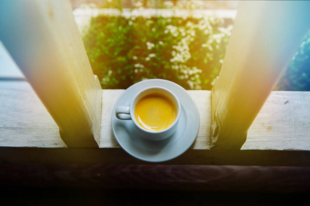 白一碟每天早上喝咖啡在太阳上的玻璃桌上一杯。早上的沙发上家的门廊，蒸汽