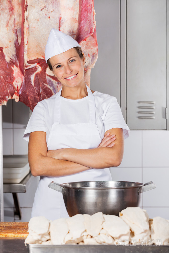 双臂交叉在店里的女屠夫