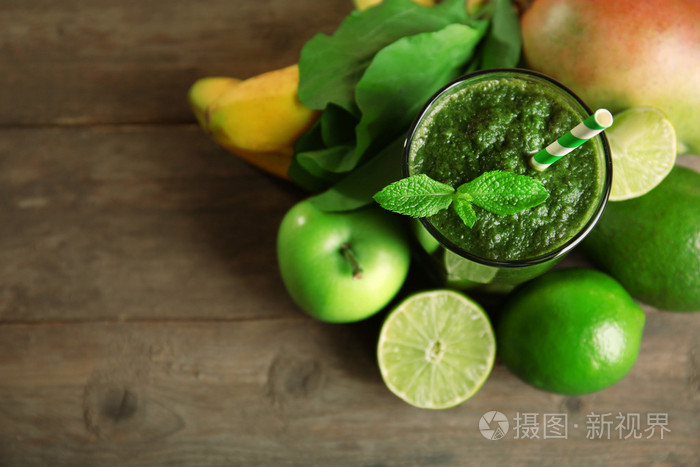 绿色健康果汁水果和香草木制的桌子上关闭