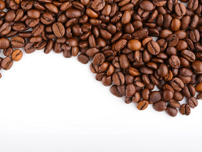 在白色背景下分离的烤咖啡豆。烘焙咖啡豆背景特写。咖啡豆桩从顶部白色背景与复制空间的文本。早上好
