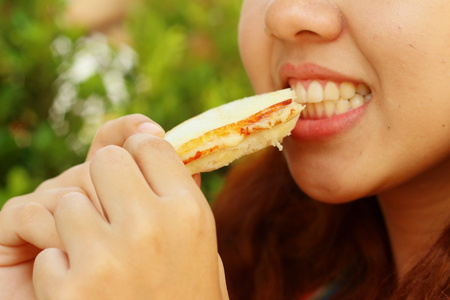 女人吃火腿和奶酪三明治