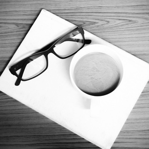 咖啡杯和戴着眼镜黑色和白色的笔记本颜色色调