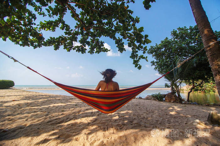 在吊床上热带海滩上的女孩