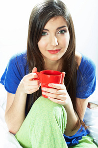 睡衣便装和红色咖啡杯里坐着的女人