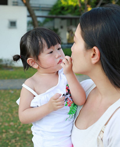 特写母亲抱着婴儿，是就在公园里哭和笑