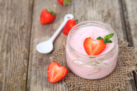 草莓酸奶和成熟草莓木制的桌子上