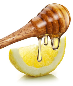 木头棍子在浇上一片柠檬蜂蜜