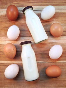 鸡蛋与木制背景上的牛奶瓶