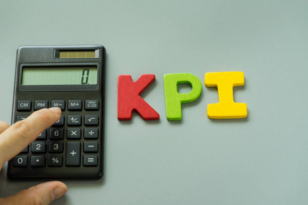 手指在计算器与多彩木制字母 Kpi Kpi g