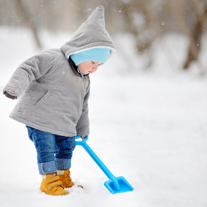 美丽的幼儿男孩玩雪