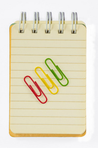 彩色回形针和孤立的白色背景上的笔记本